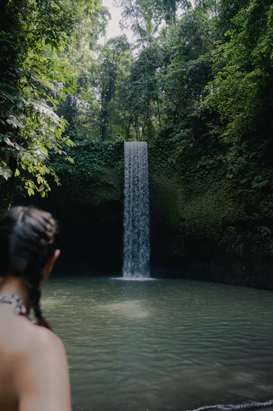 A woman standing in front of a waterfall