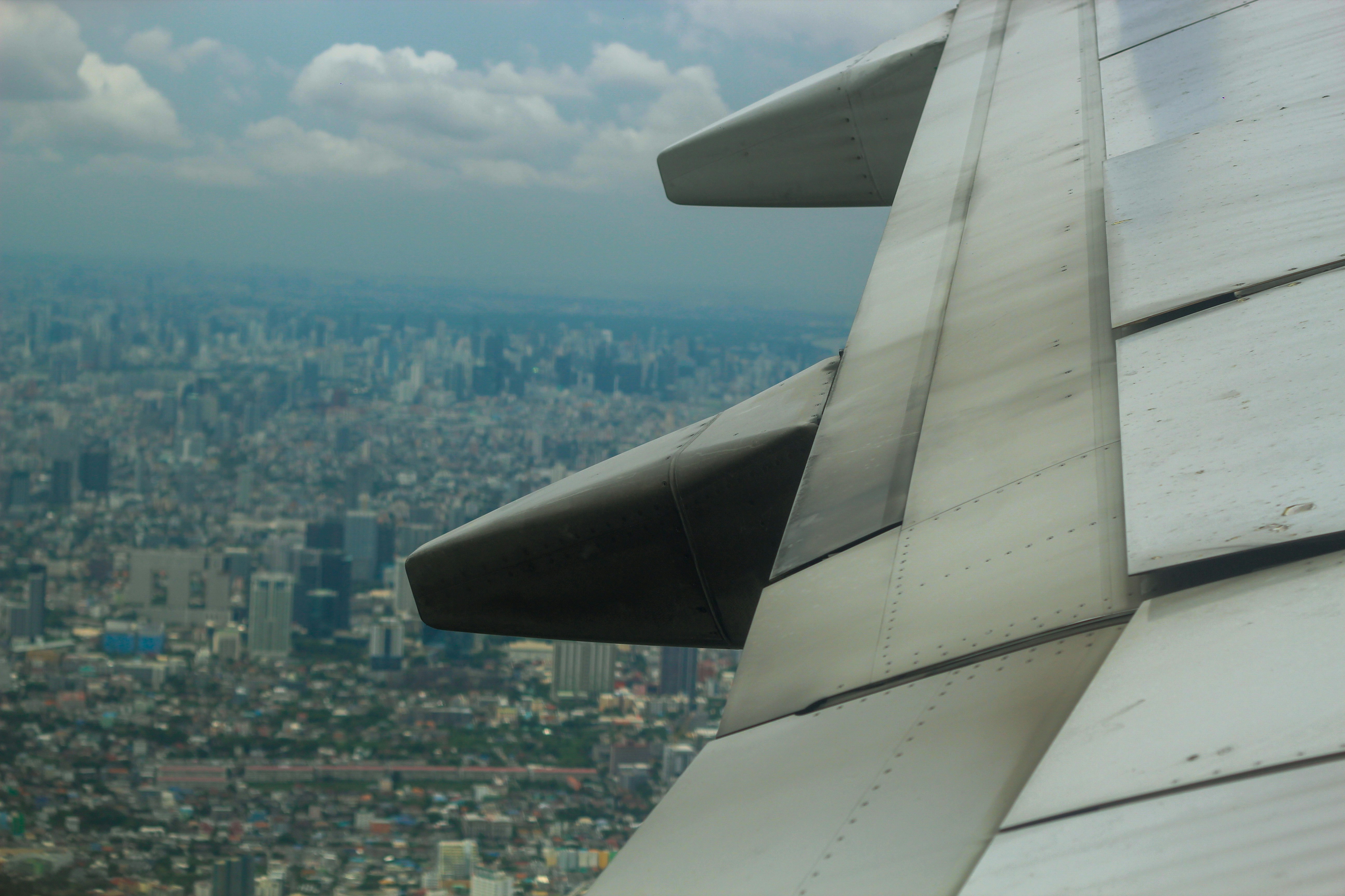 The wing of an airplane flying over a city, The view from a plane flying over Bangkok city
