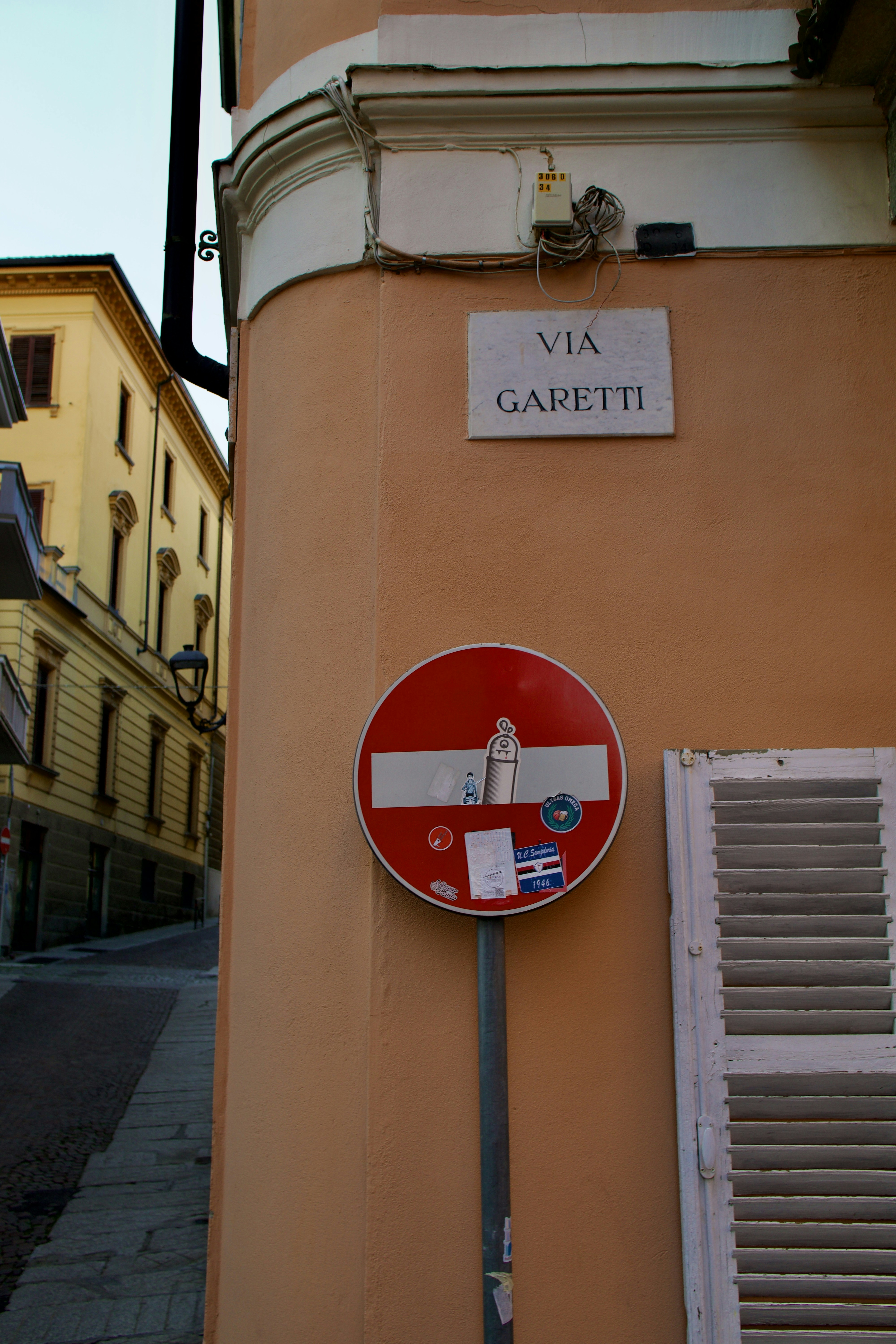 A red and white street sign on the side of a building