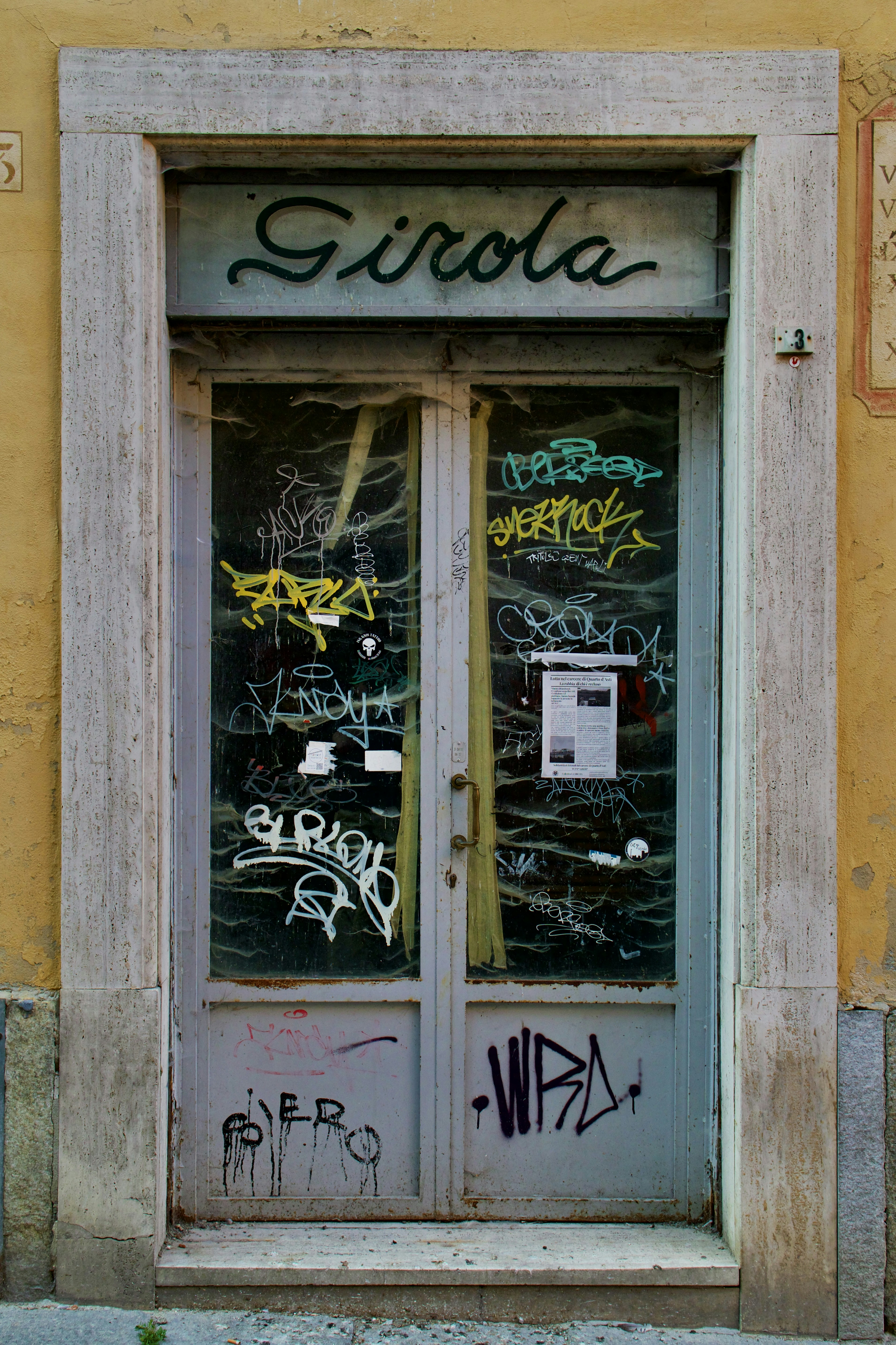Una puerta con un grafiti escrito frente a un edificio