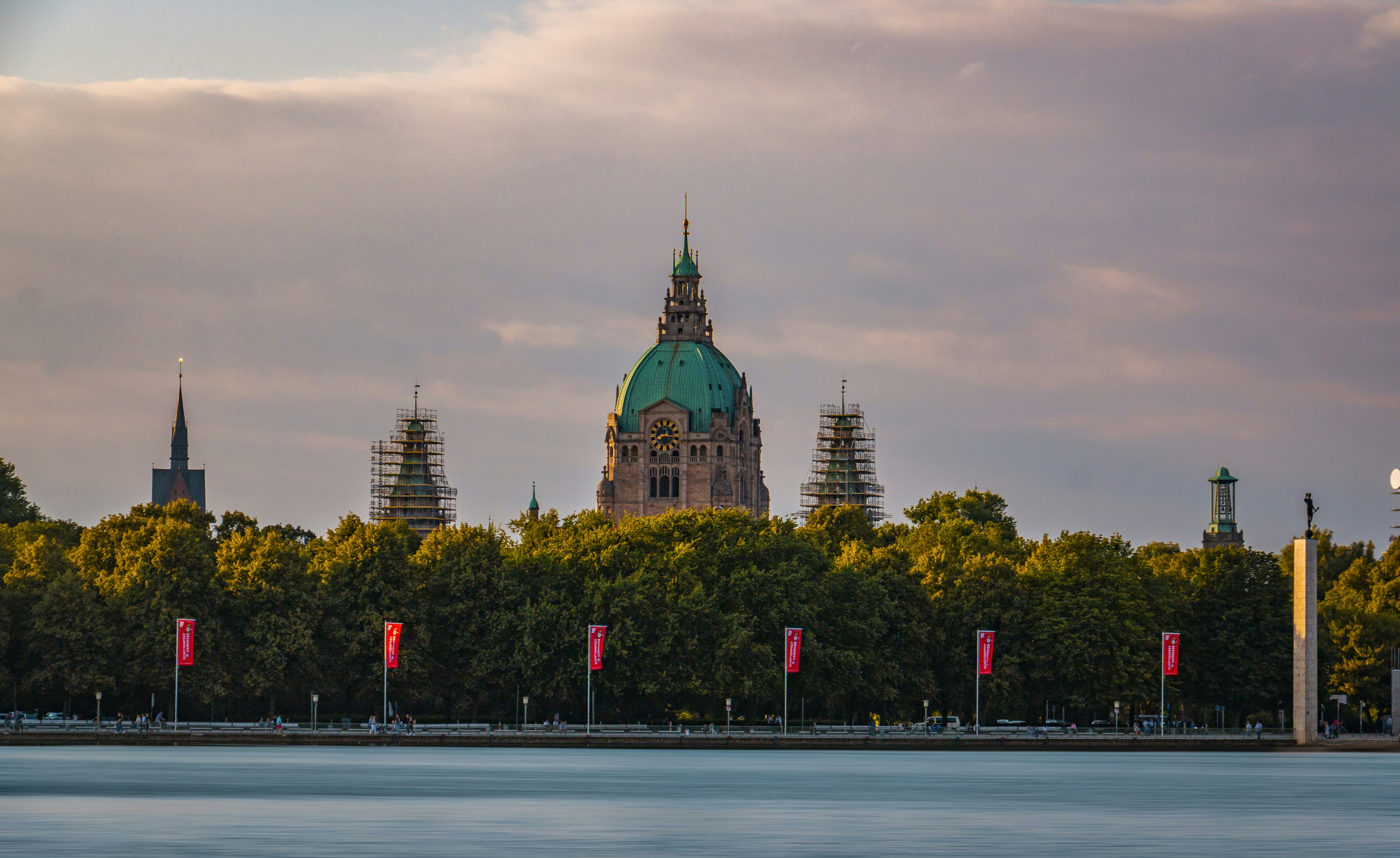 A large building with a green dome near a body of water