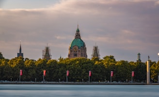 A large building with a green dome near a body of water