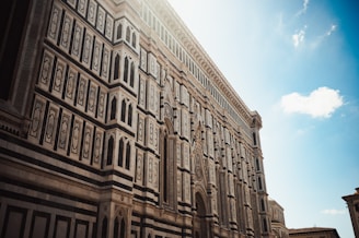 A tall building with many windows and a sky background
