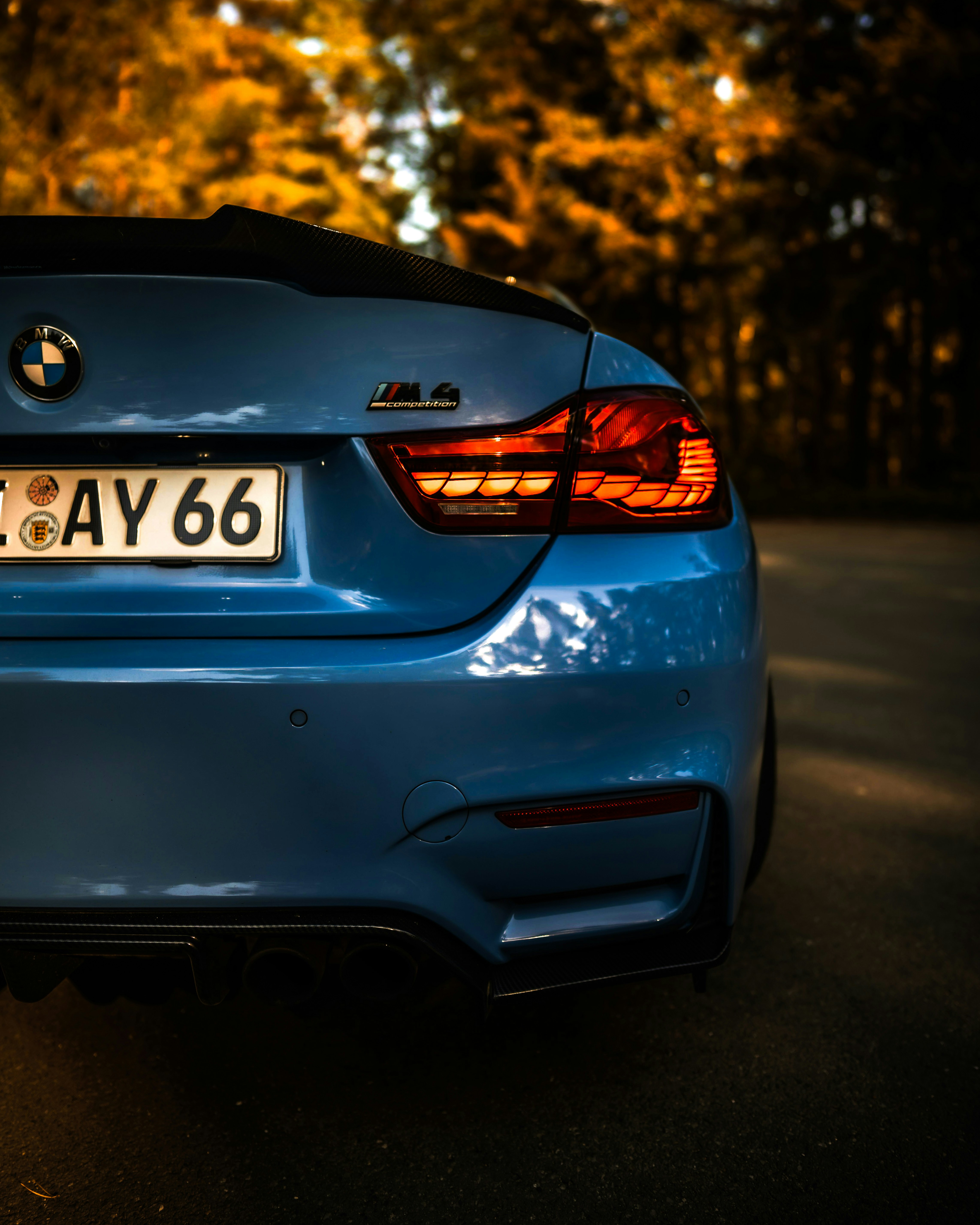 Blue BMW M4 Competition in motion on empty road, dusk lighting, cinematic automotive photography