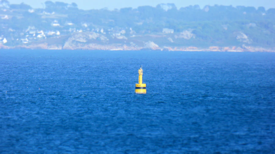 A single yellow mooring buoy drifting on deep blue open water