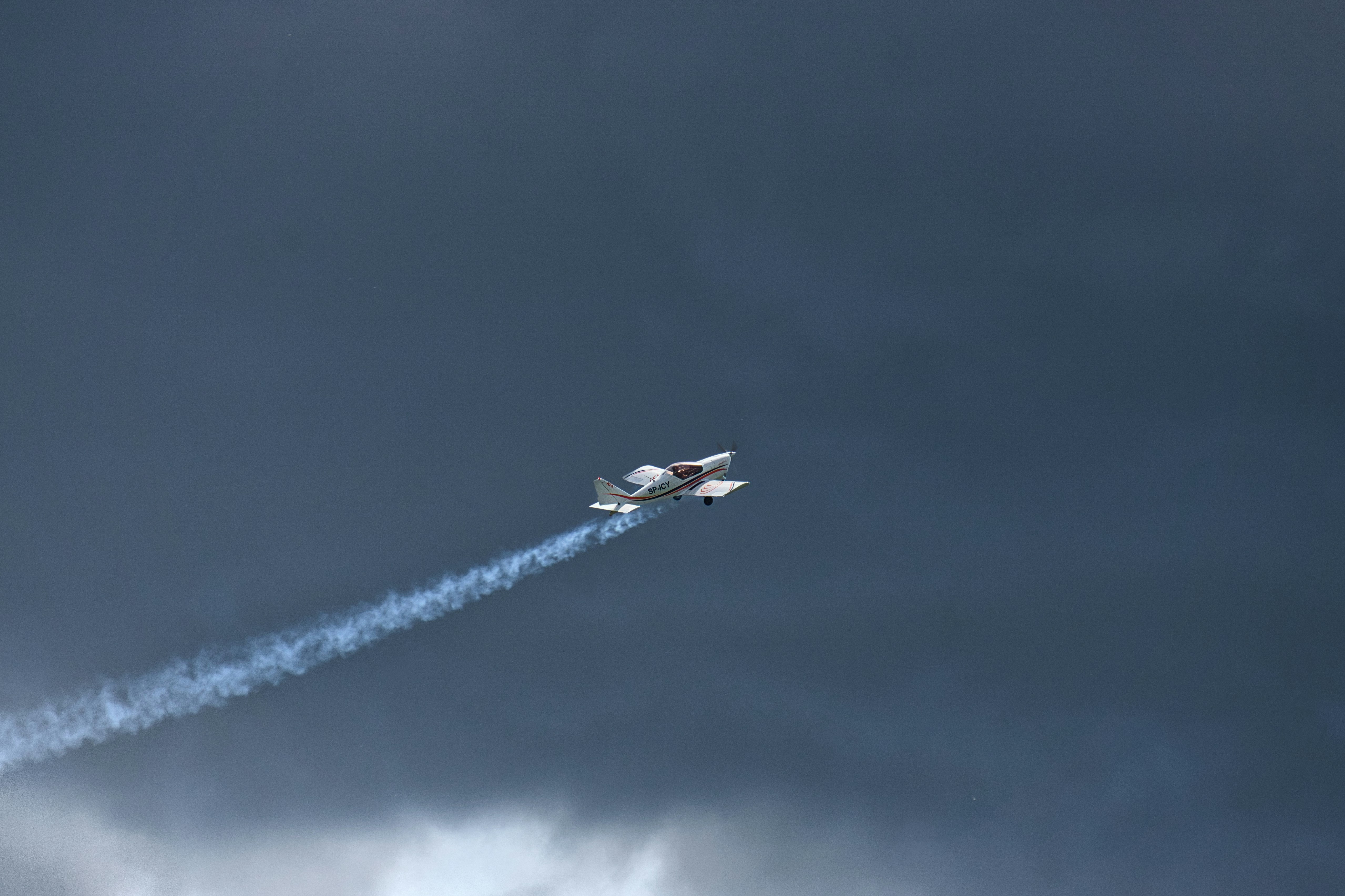 A plane flying in the sky with smoke coming out of it, 