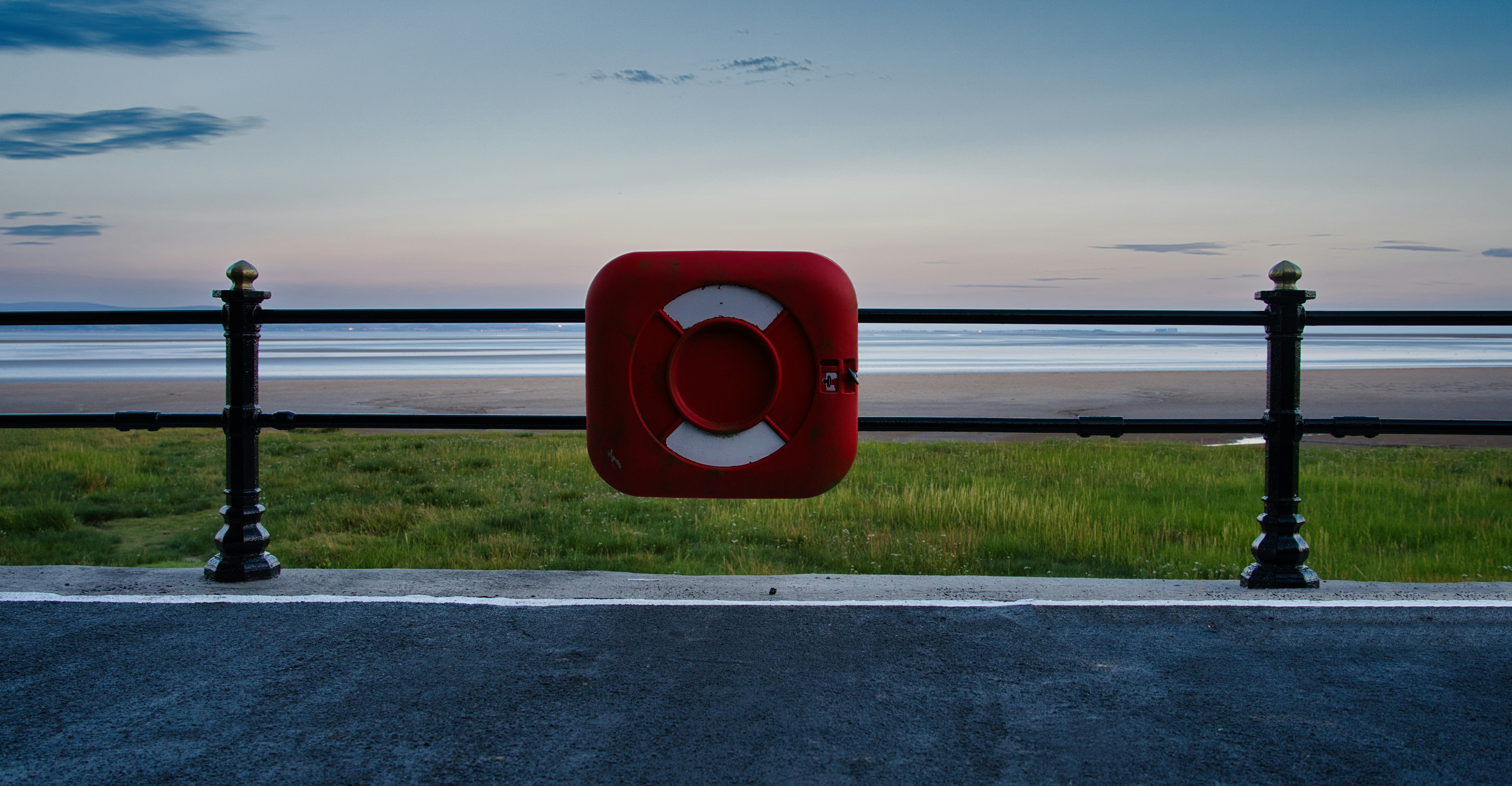 A red square sign sitting on the side of a road