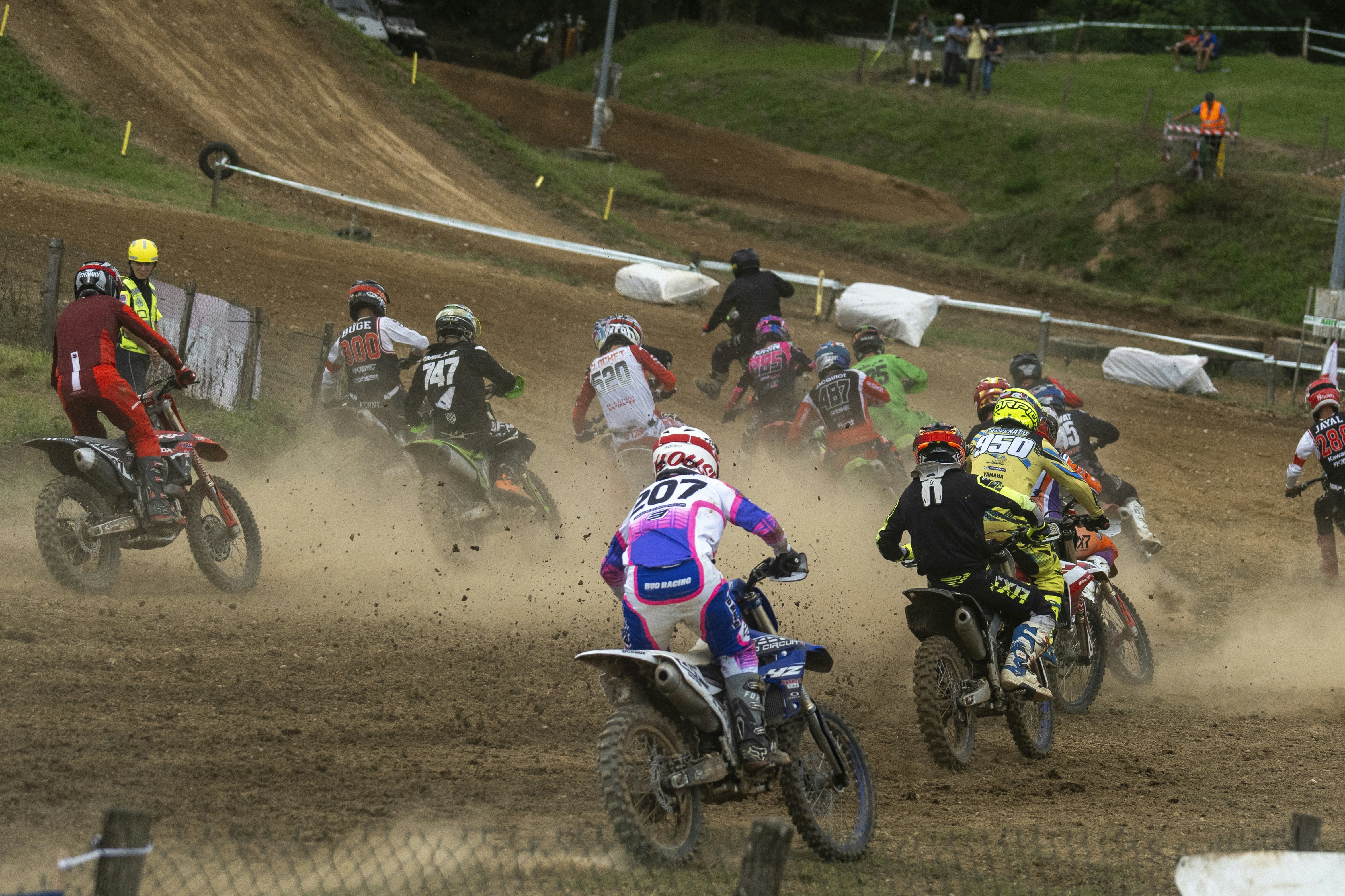 A group of people riding dirt bikes on a dirt track