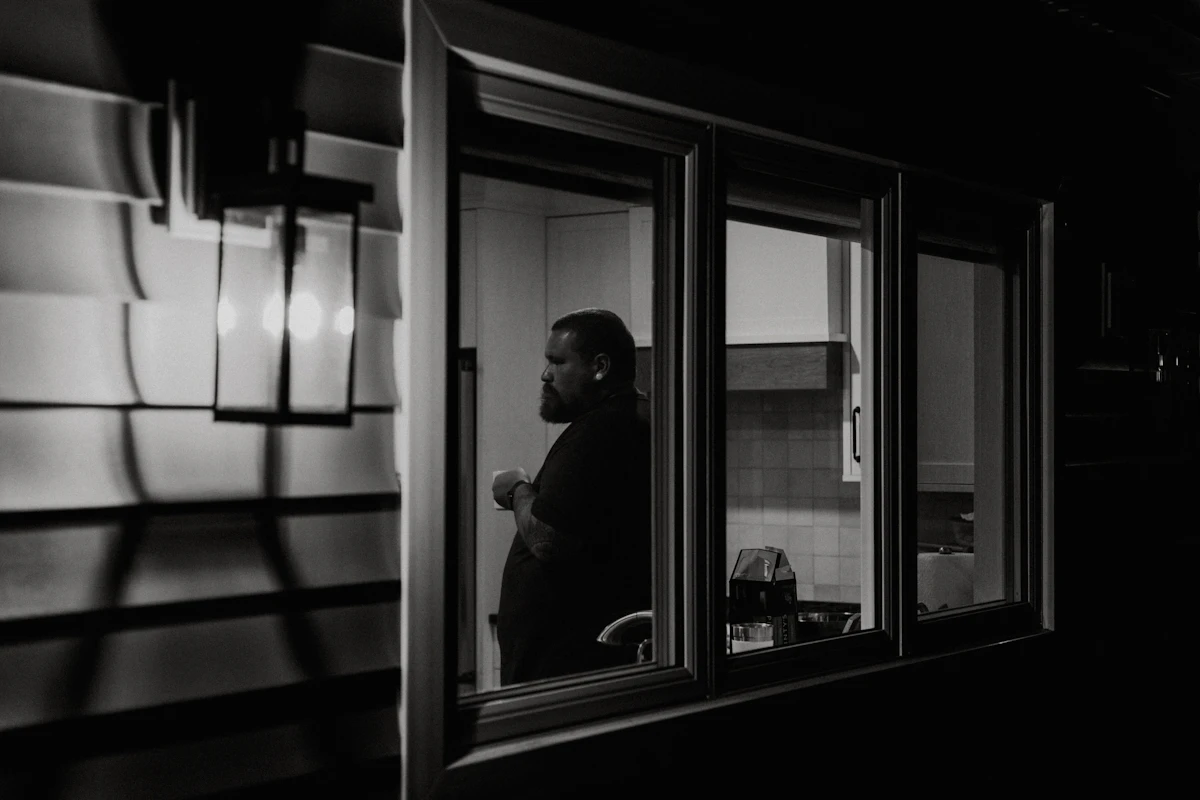 Man looking out a window during a quiet coffee break.