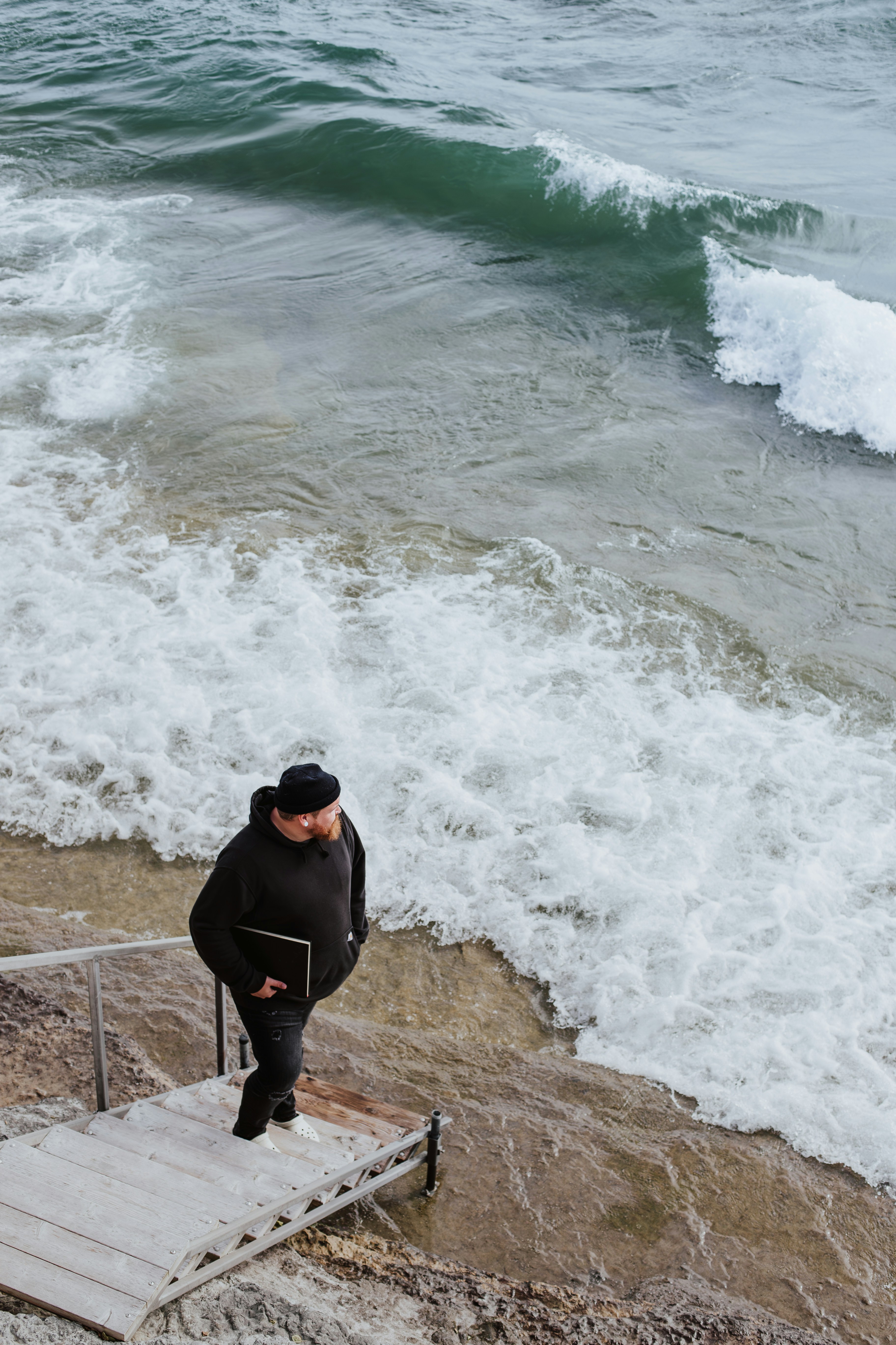 A man standing on a set of stairs next to the ocean