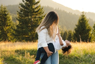 A woman holding a child in a field