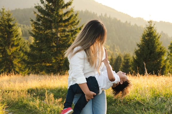 A woman holding a child in a field