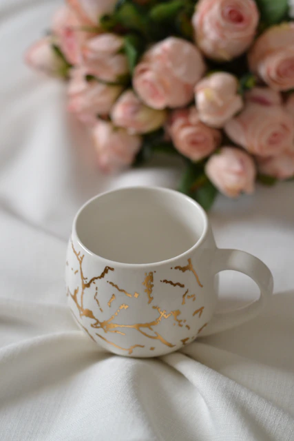 A coffee cup sitting on top of a white cloth