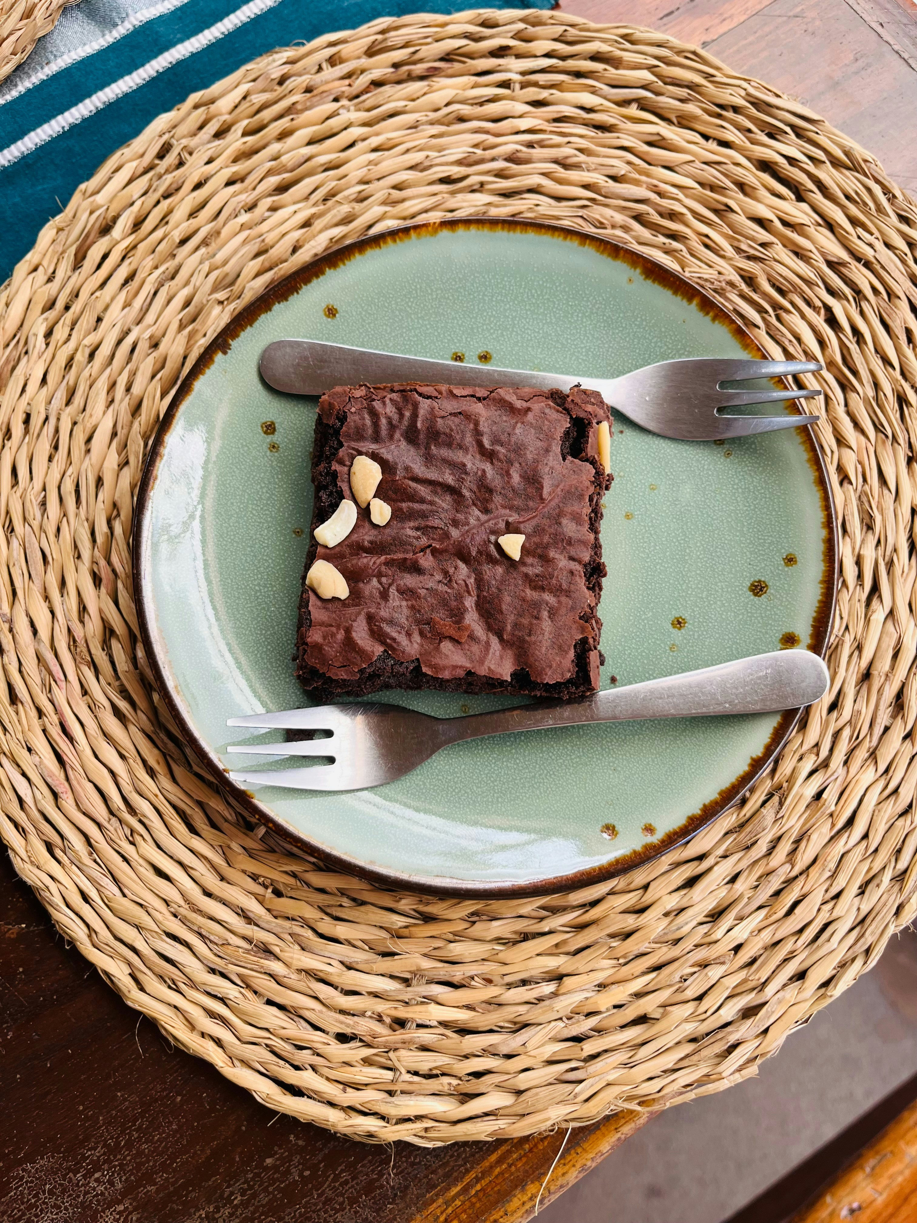 Brownie de chocolate Frisby: porción individual de brownie con nueces y salsa de chocolate en plato blanco