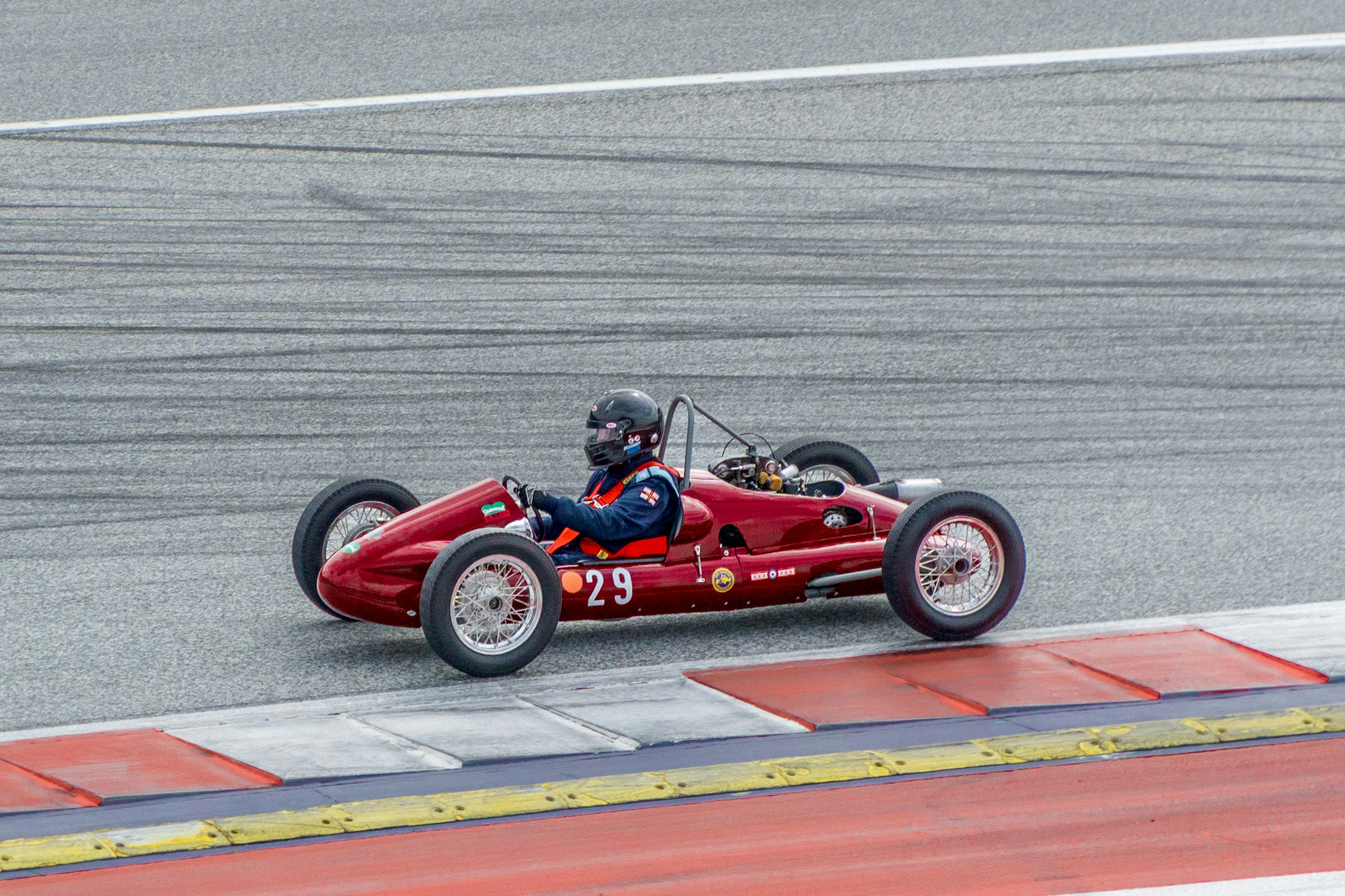 A man driving a red race car on a race track photo – Free Wallpaper ...