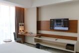 A hotel room with a flat screen TV on the wall