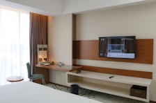A hotel room with a flat screen TV on the wall