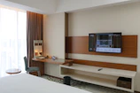 A hotel room with a flat screen TV on the wall