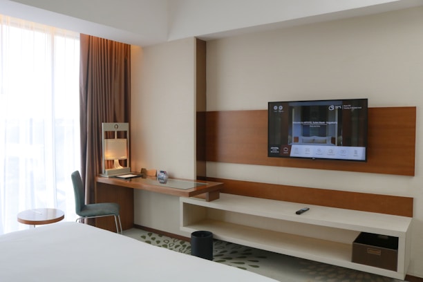 A hotel room with a flat screen TV on the wall