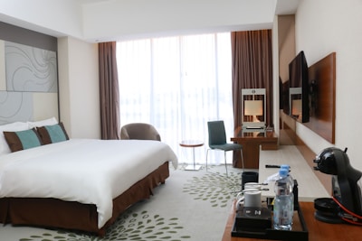 A hotel room with a large bed and a flat screen TV