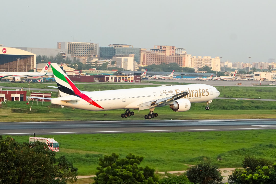 A large jetliner taking off from an airport runway, Emirates Boeing 777-300ER