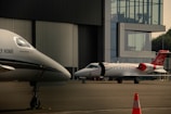 A couple of small planes parked in front of a building