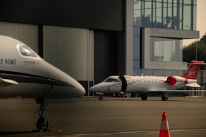 A couple of small planes parked in front of a building
