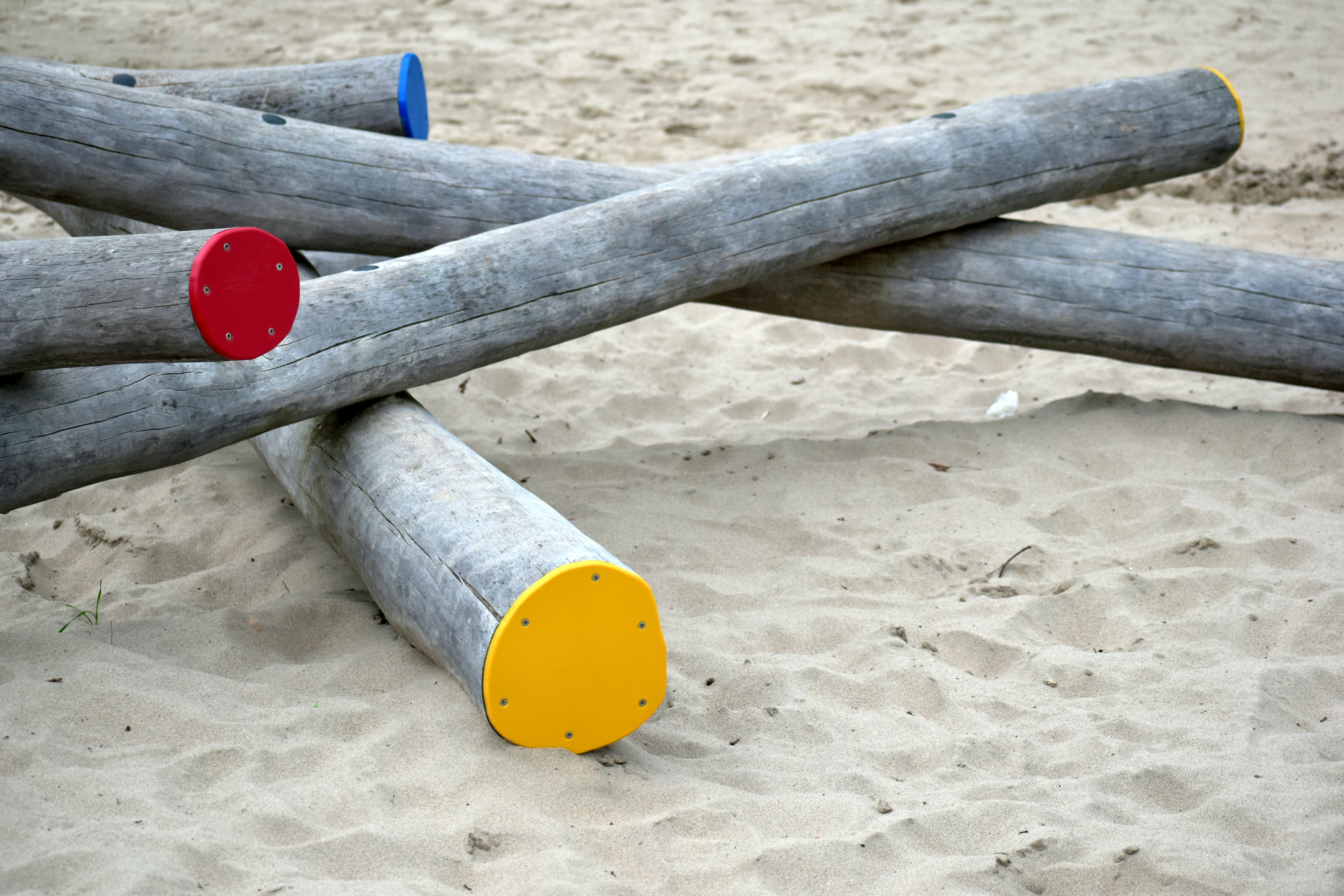 A pile of logs sitting on top of a sandy beach