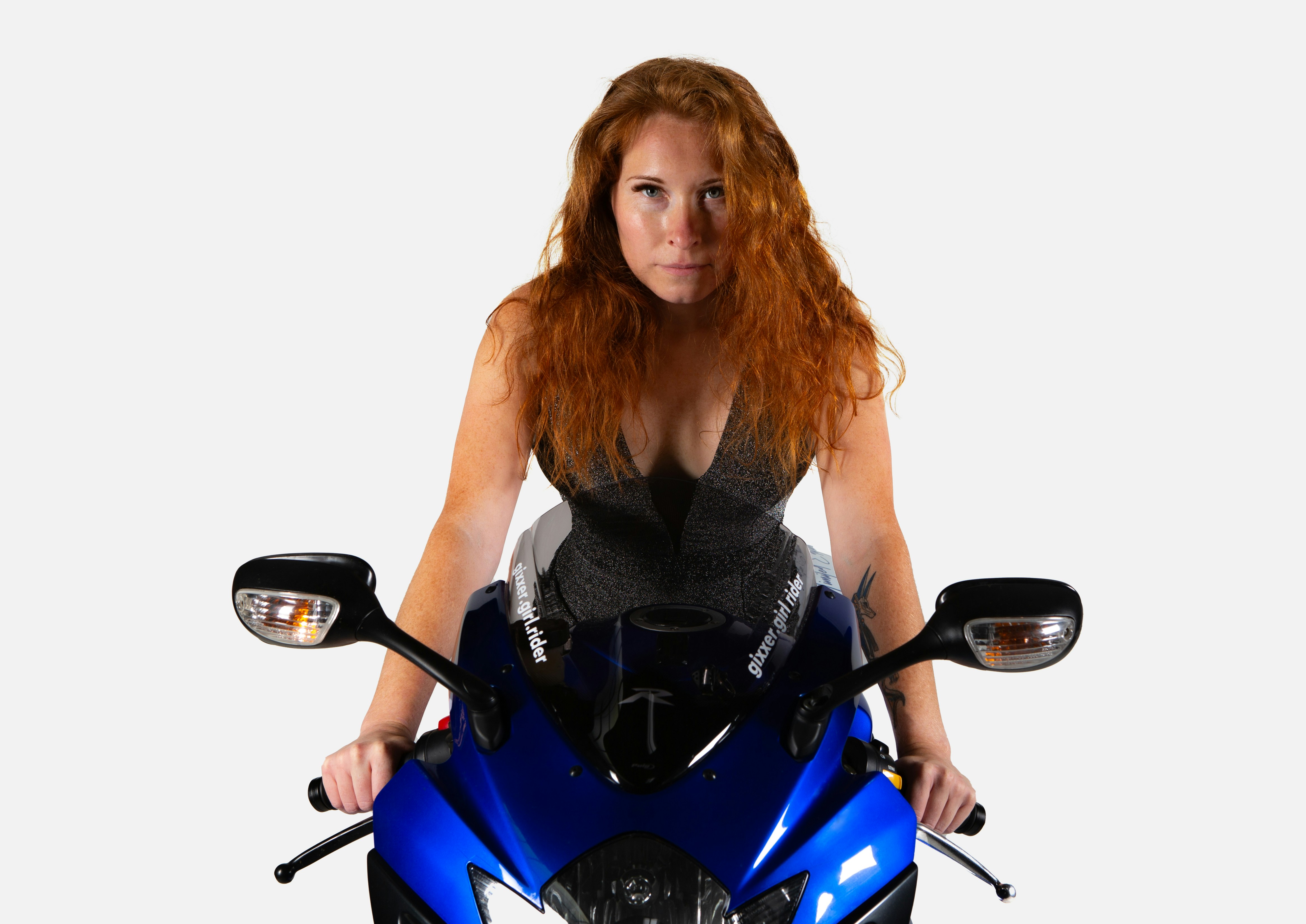 Eine Frau, die auf einem blauen Motorrad sitzt und für ein Foto posiert