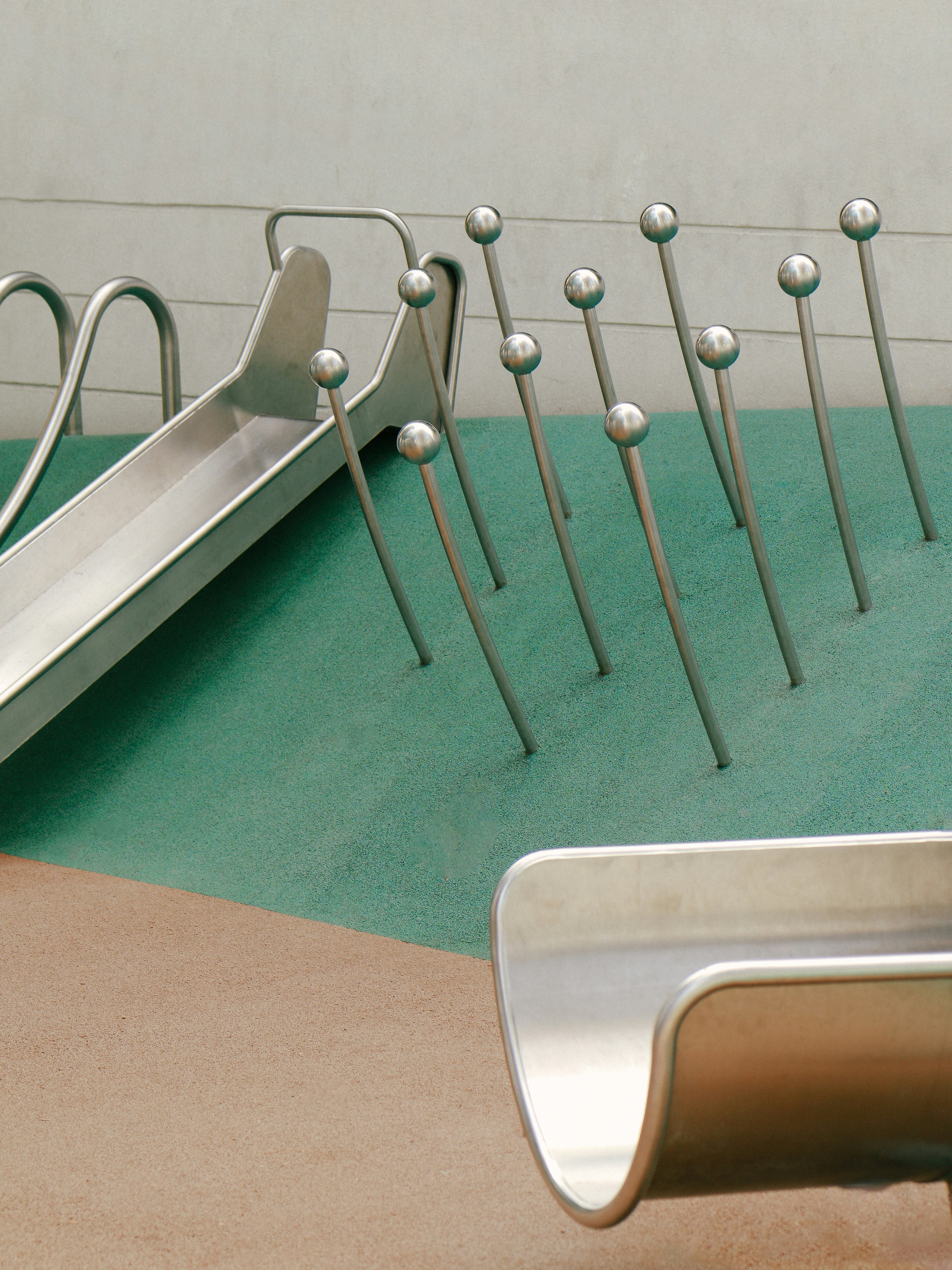 A metal slide sitting on top of a green floor