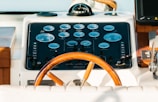 The steering wheel of a boat with a clock on it