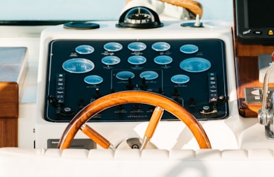 The steering wheel of a boat with a clock on it