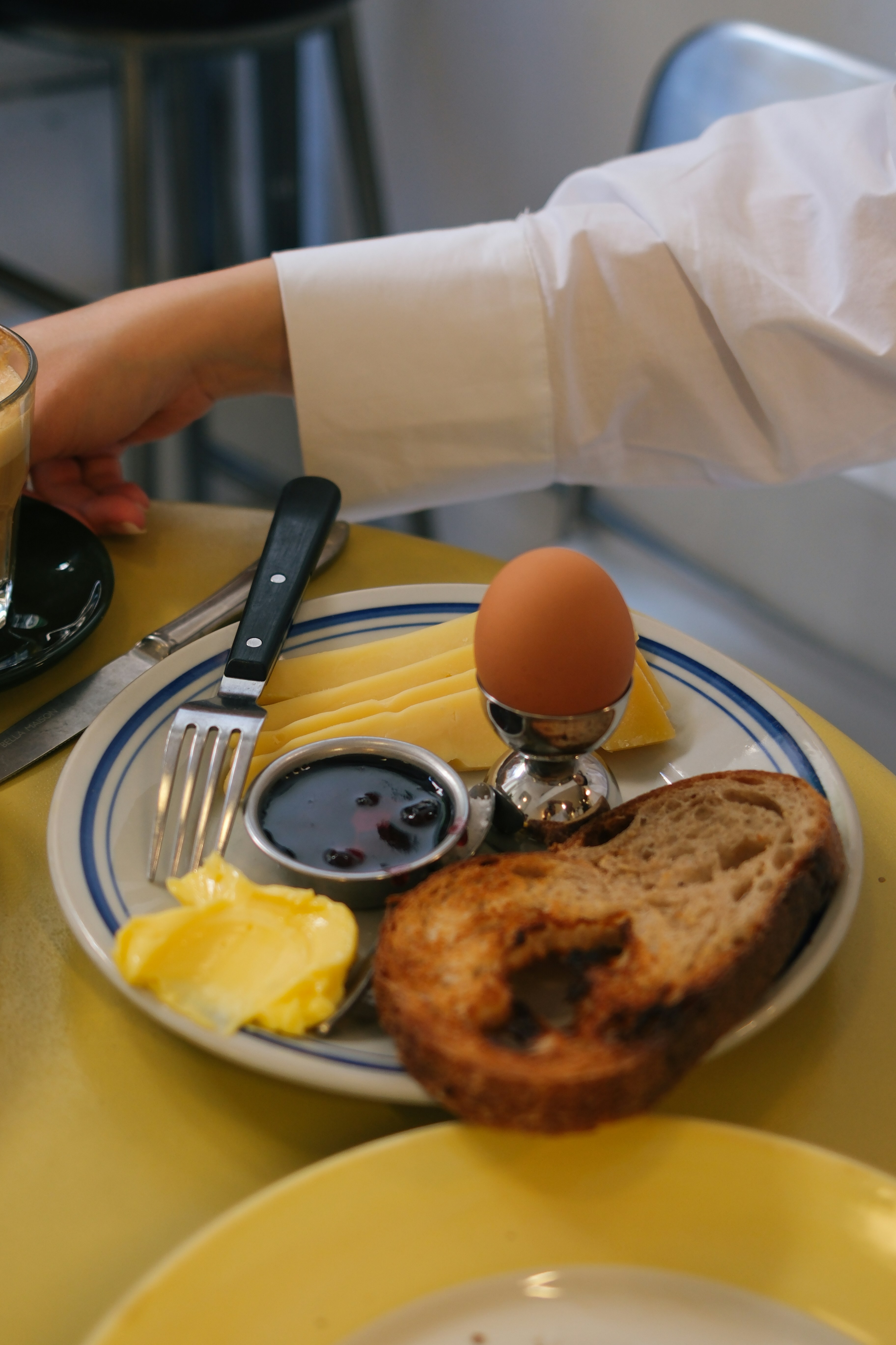 A plate of food on a table with a cup of coffee