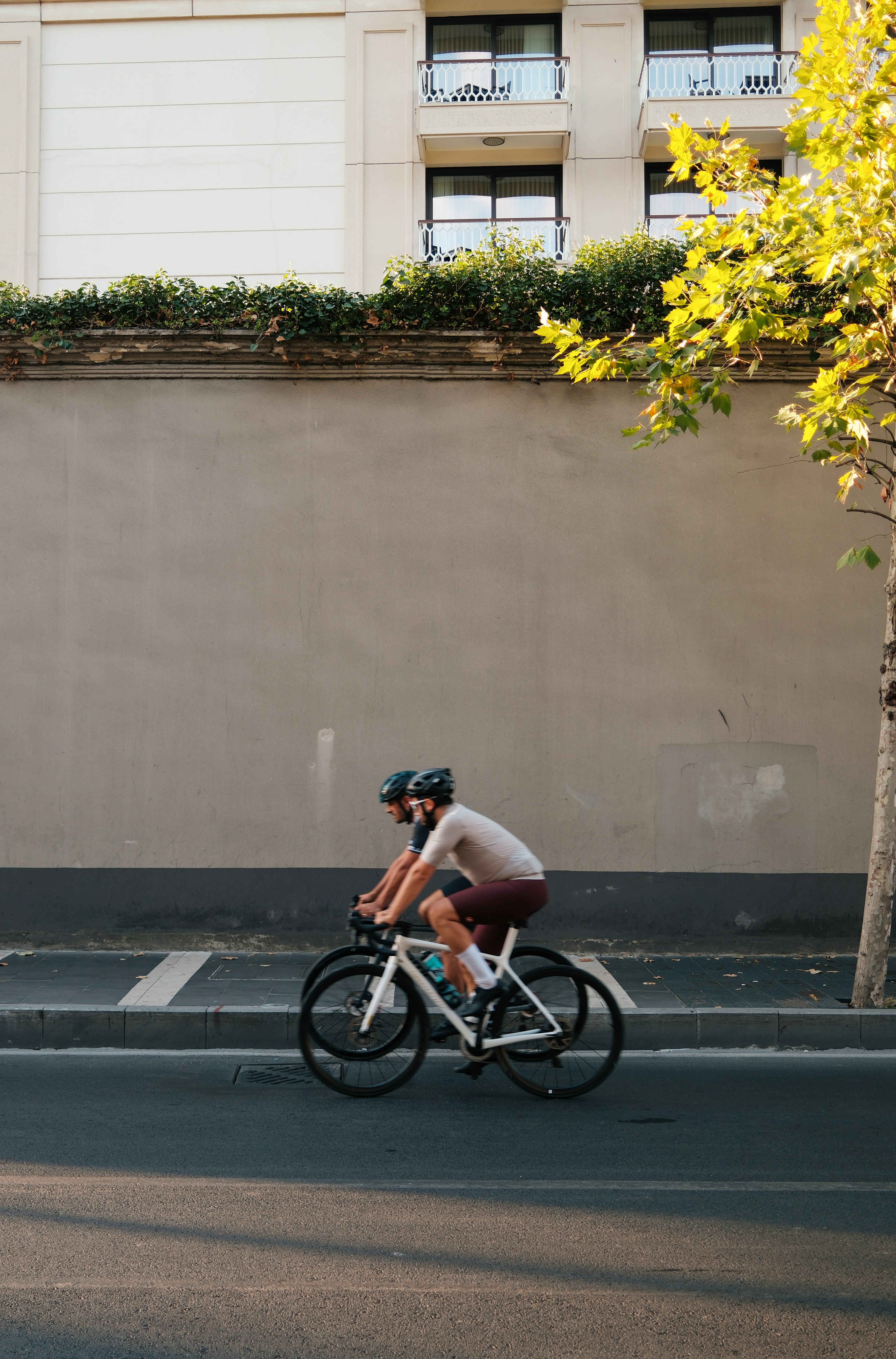 A man riding a bike down a street next to a tall building