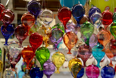 A bunch of colorful wine glasses hanging from a ceiling