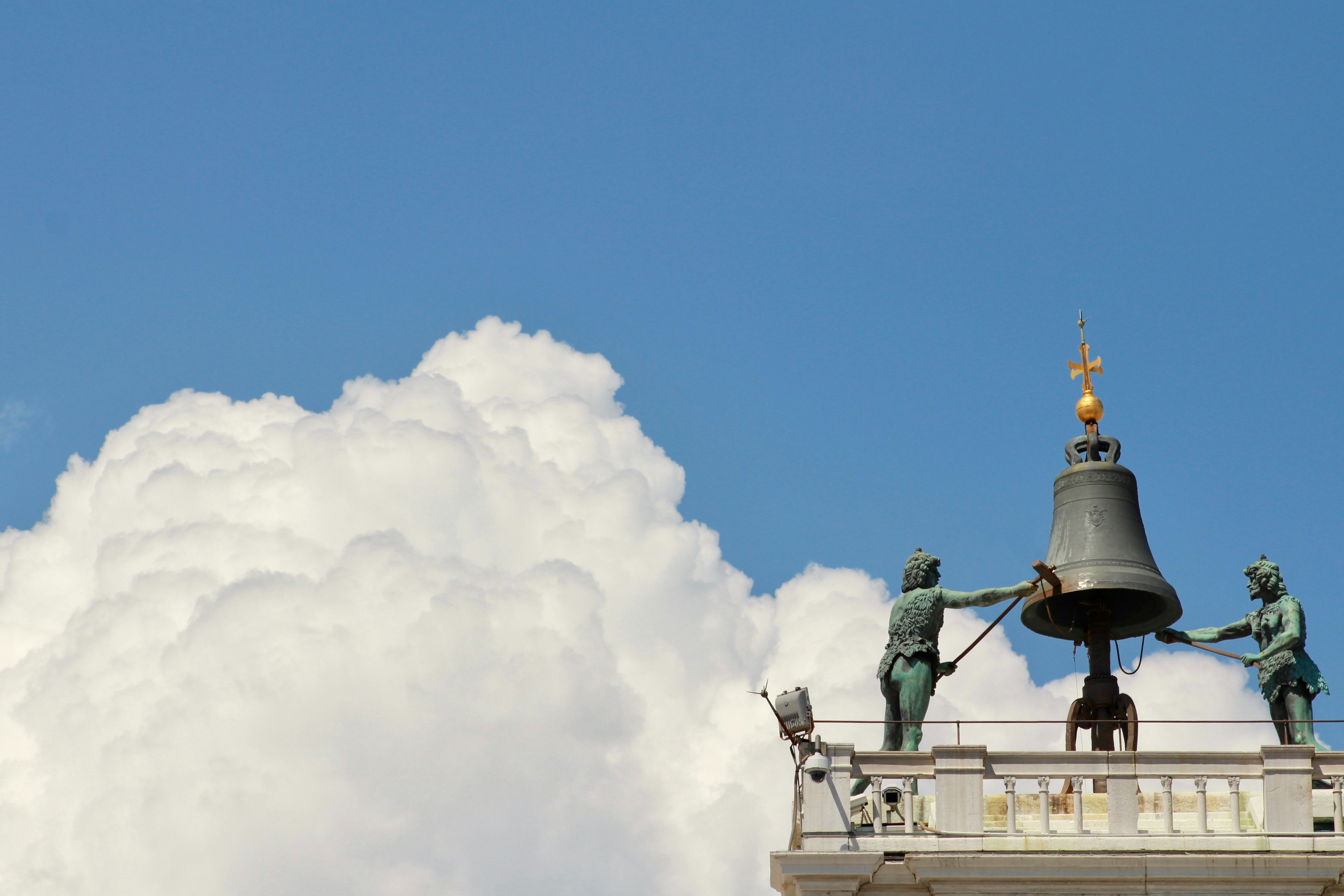 A bell tower with statues on top of it