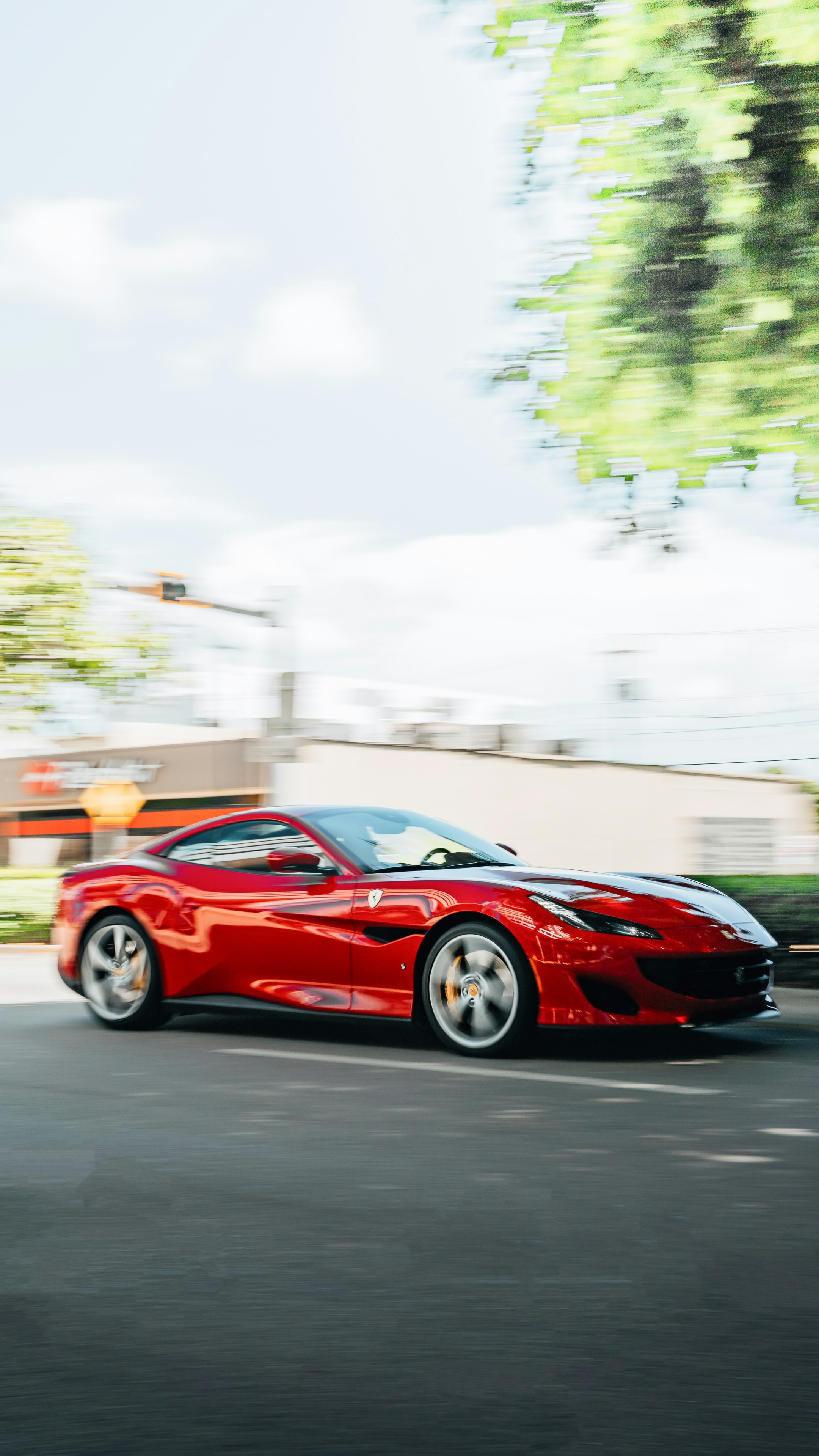 A red sports car driving down a street