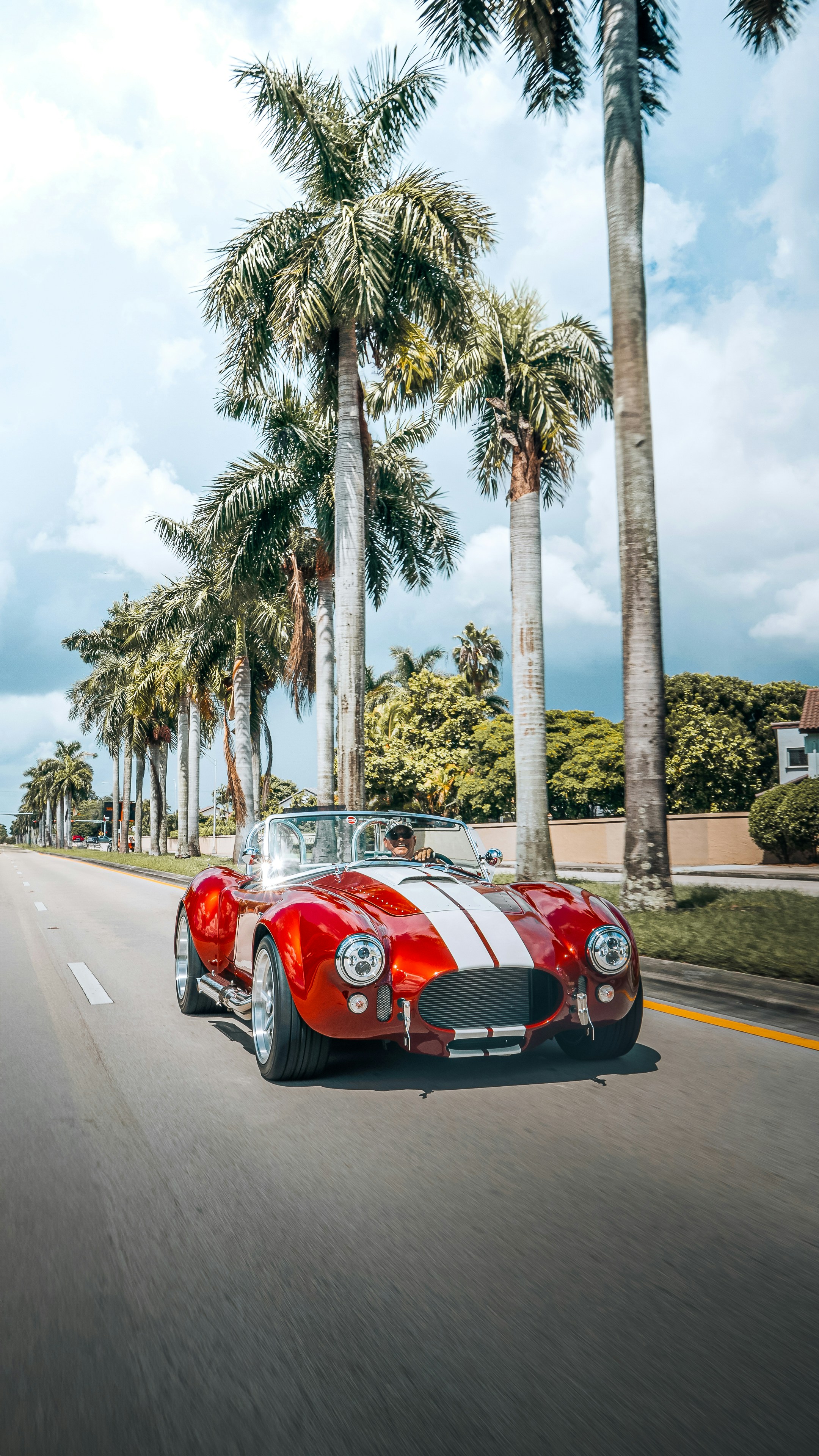 A red and white car driving down a street