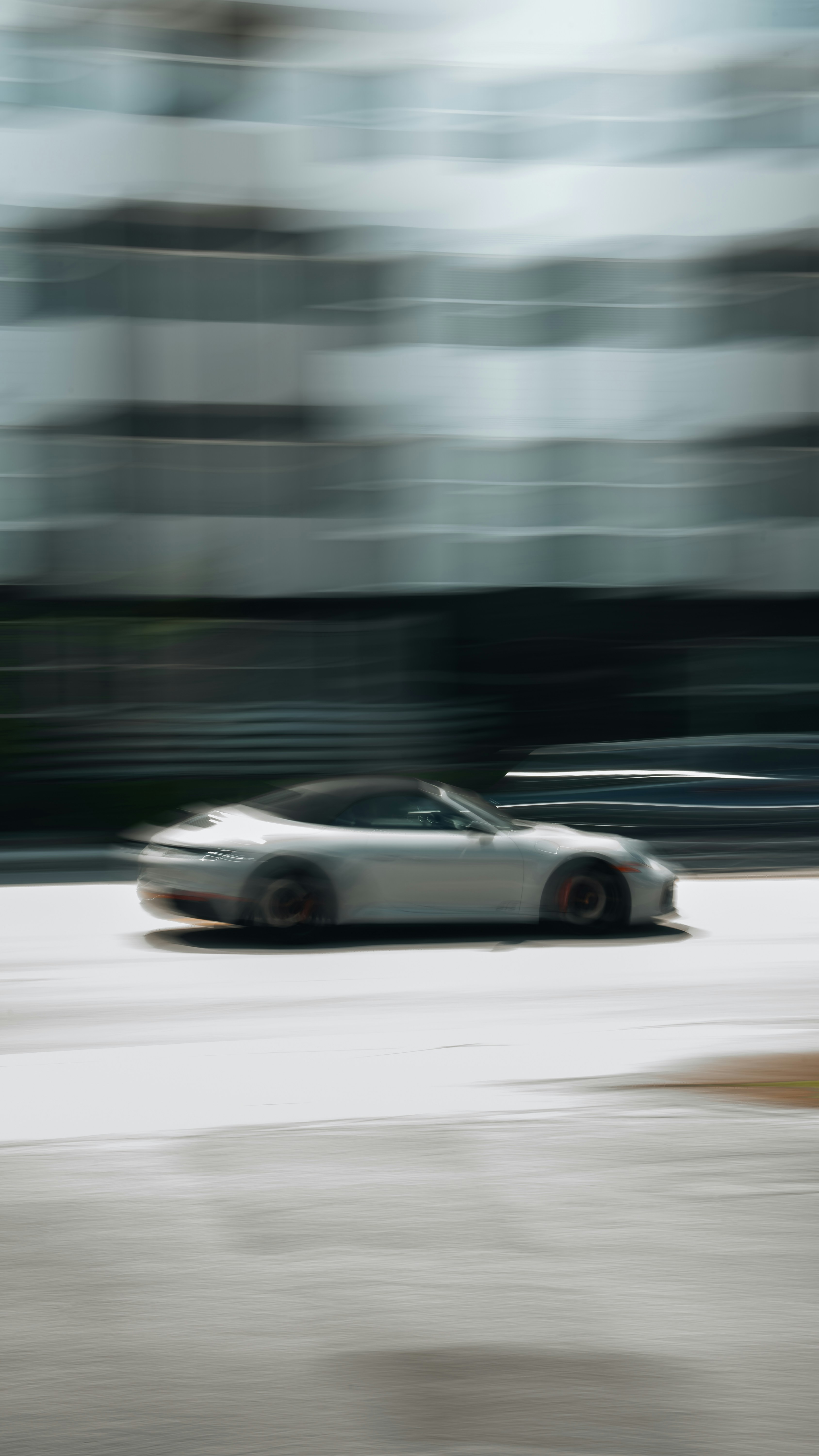 A car driving down a street next to a tall building