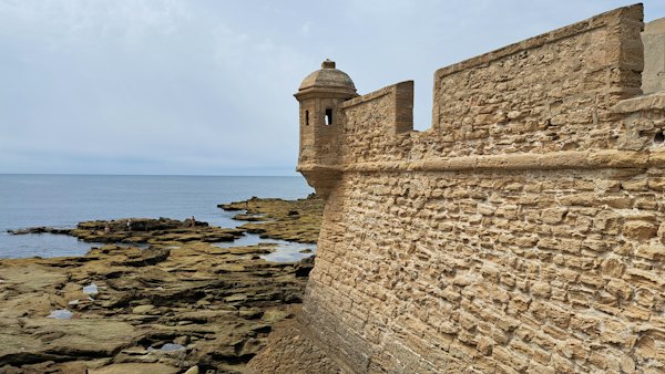 A stone wall next to a body of water — San Sebastián, Spain