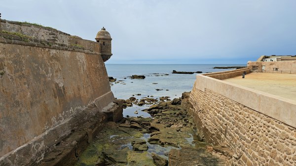 A stone wall next to a body of water — San Sebastián, Spain