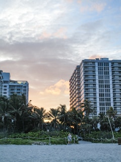 A couple of tall buildings sitting on top of a beach