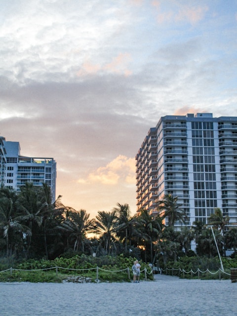 A couple of tall buildings sitting on top of a beach