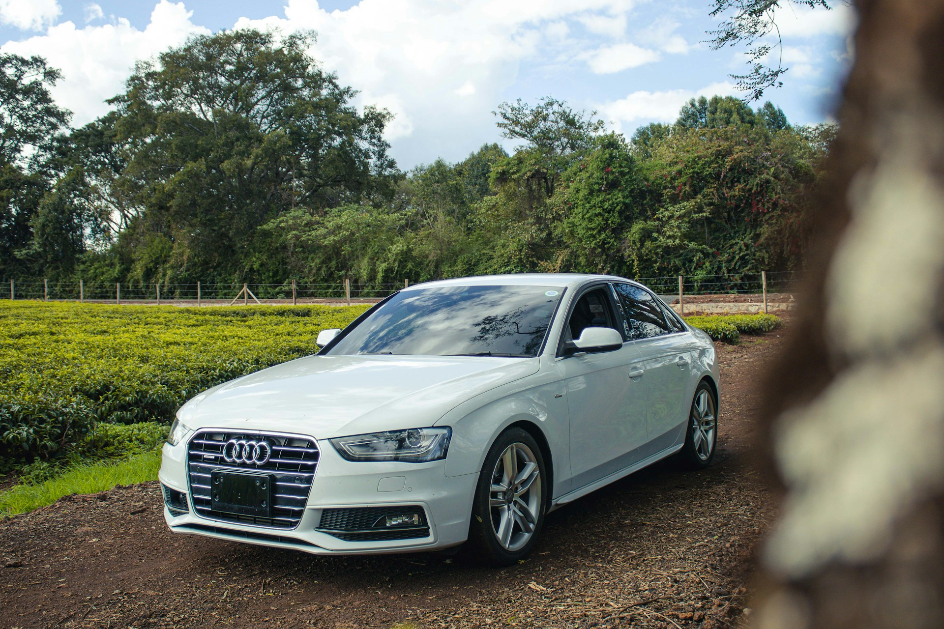 A white car parked on a dirt road
