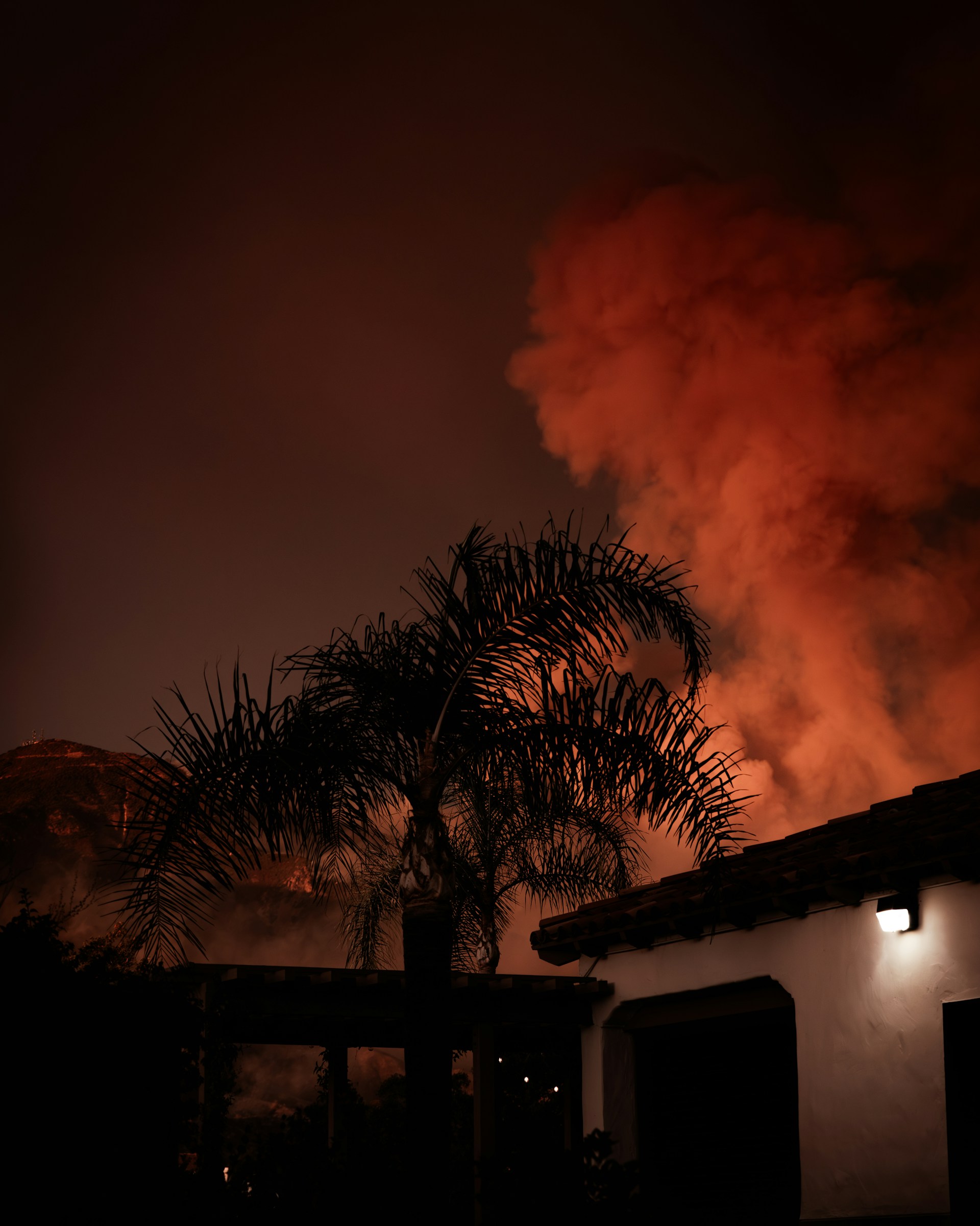 A large plume of smoke billowing out of a building