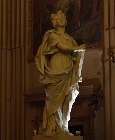 A statue of a woman holding a piece of paper