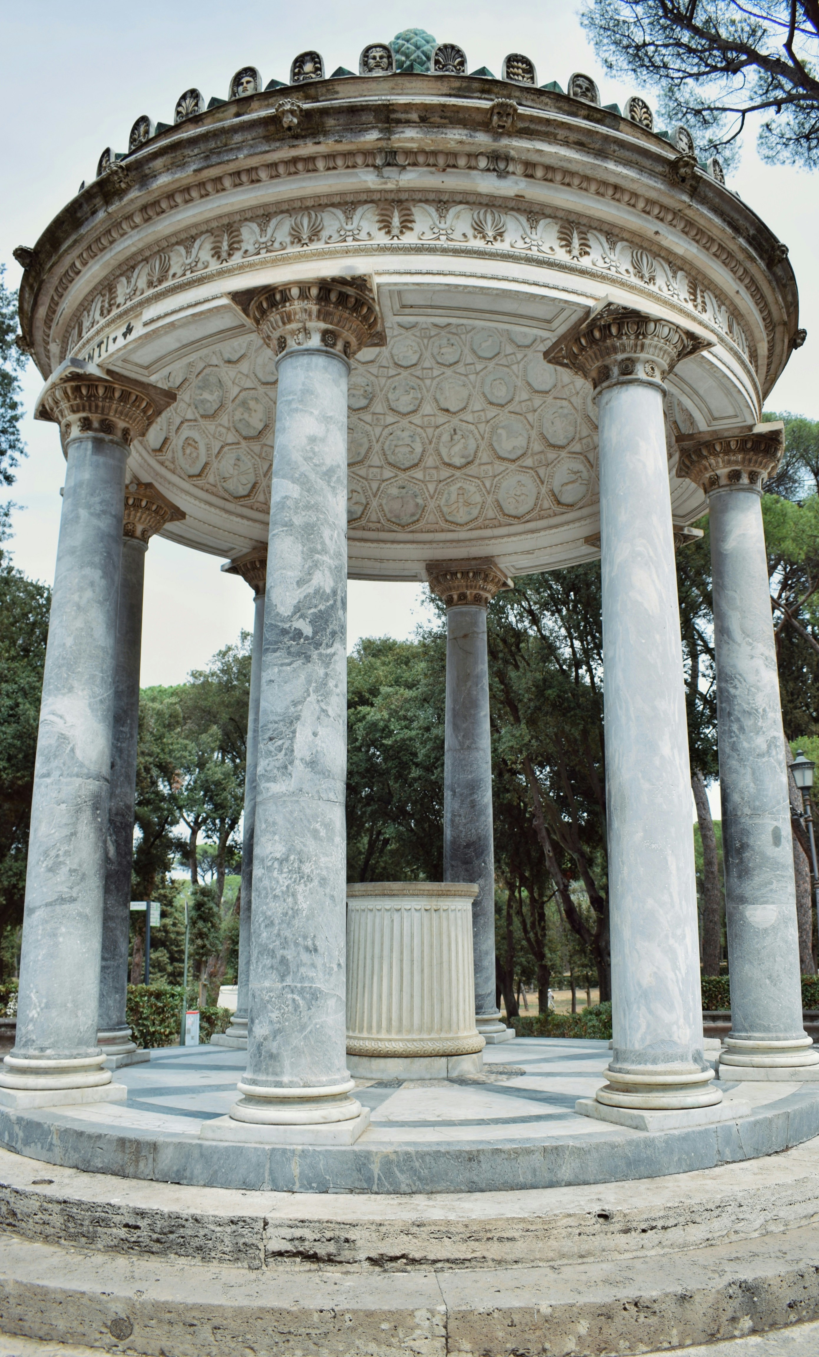 A stone structure with columns and a statue in the middle of it