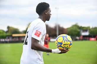 A man holding a soccer ball on a field