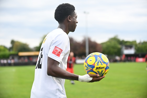 A man holding a soccer ball on a field