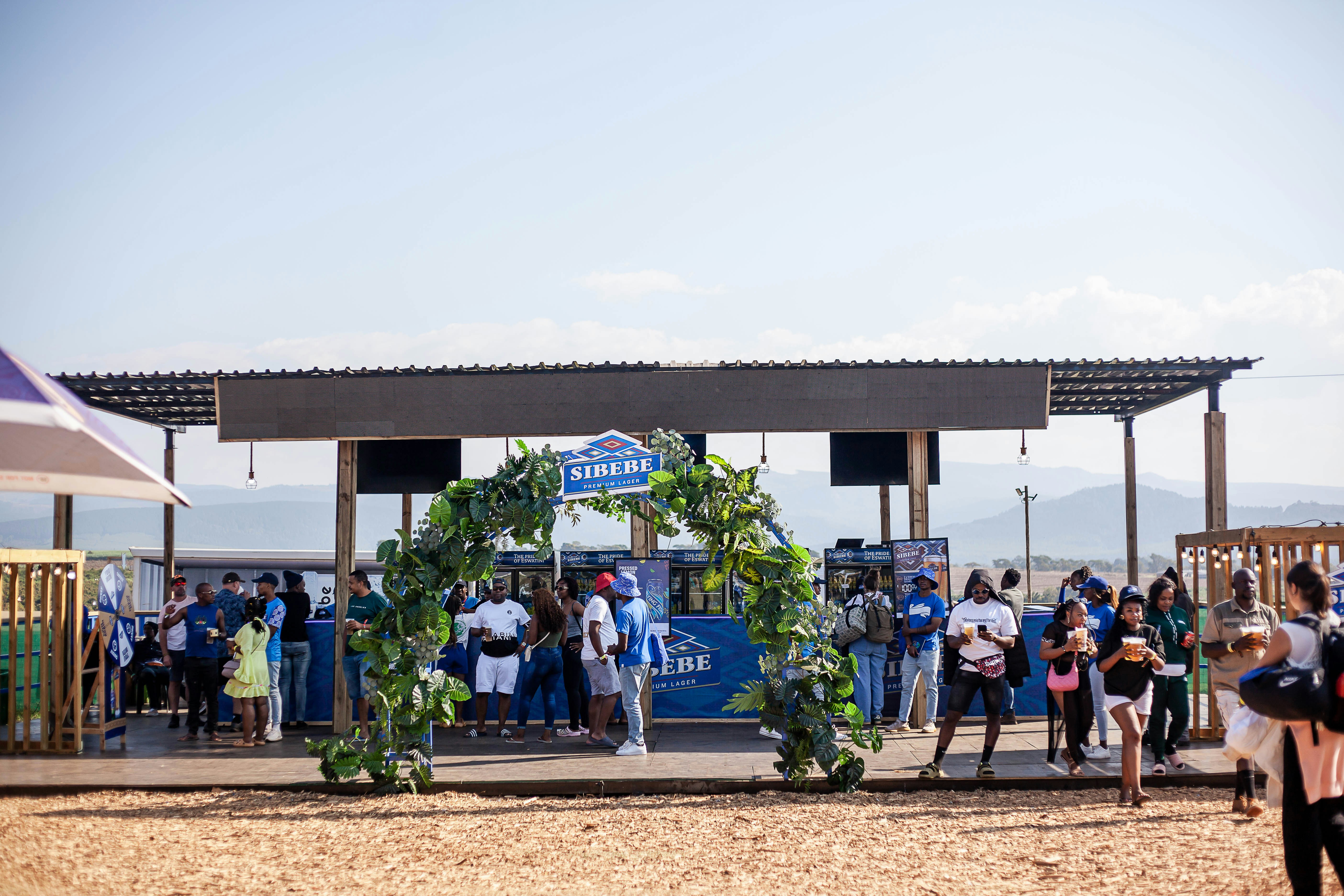 A group of people standing under a canopy on a beach